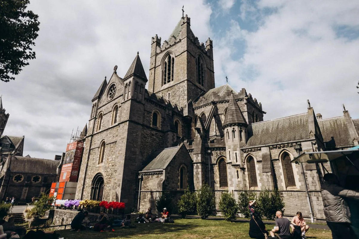 Christ Church Cathedral in Dublin, with visitors sitting on the lawn