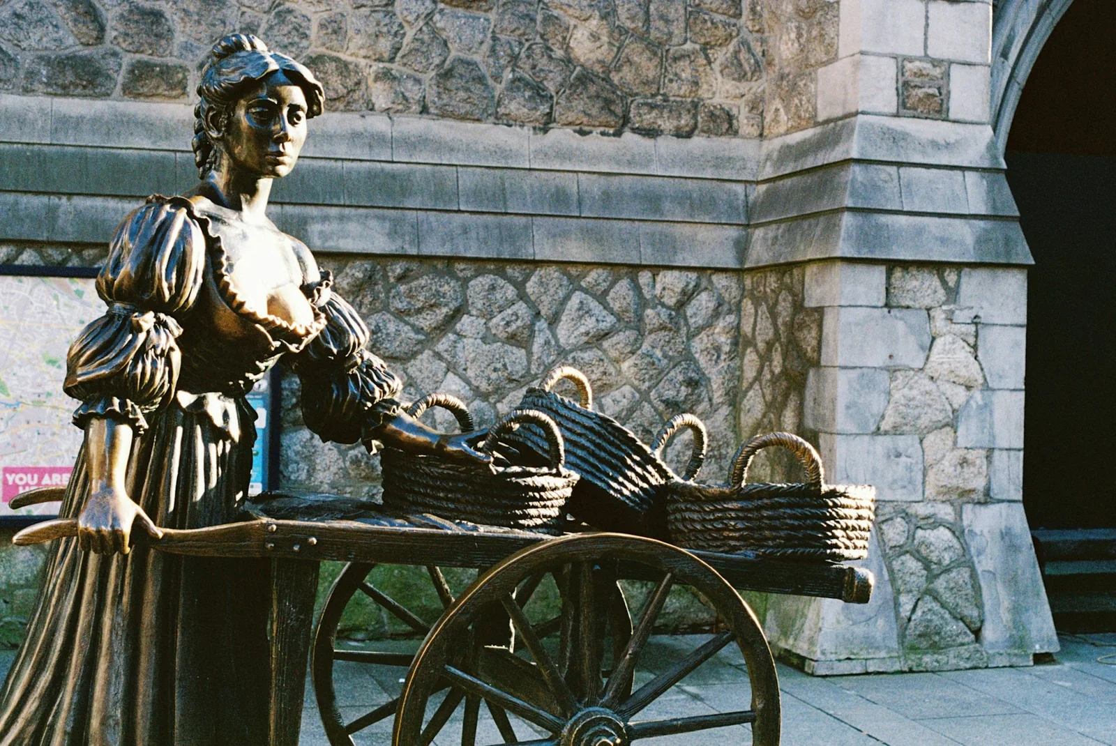 The sunlit Molly Malone statue and her cart on Suffolk Street, Dublin