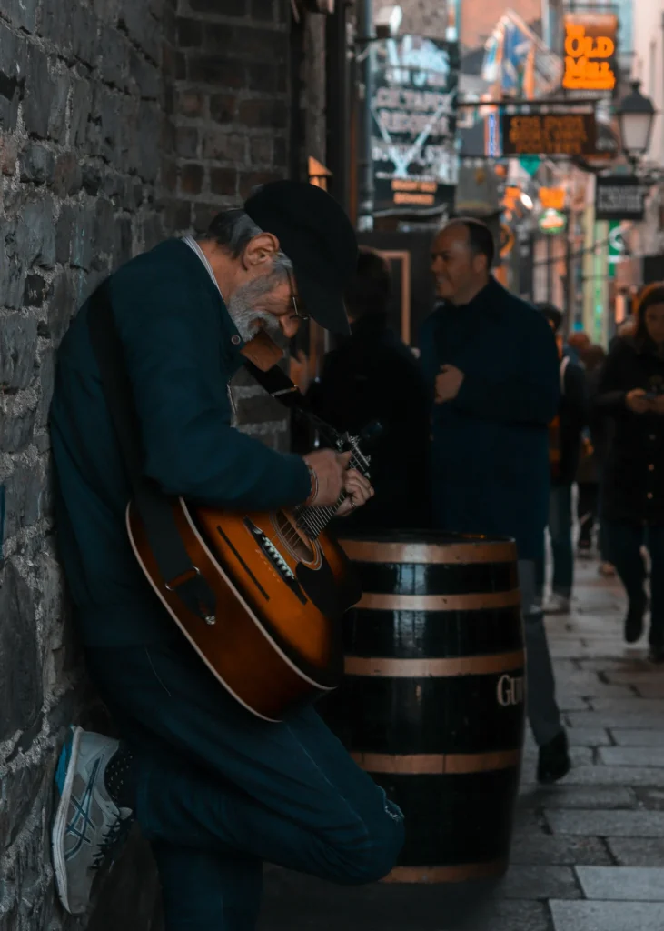 Dublin busker performing to a small crowd on a pedestrian street.